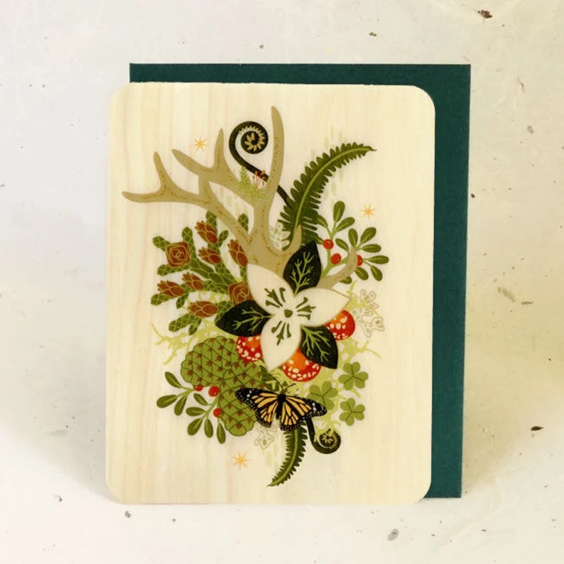 A wooden card with a forest garden and a monarch butterfly.