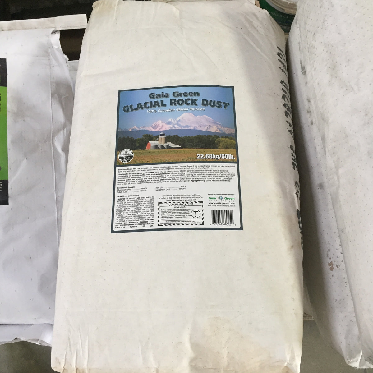 A large white bag with a label showing a farm with large mountains in the background.