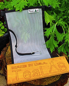 A long rectangle mesh back with a black border. It has a Tea Lab tag in the right upper corner and a wooden Tea Lab advertisement along the bottom.