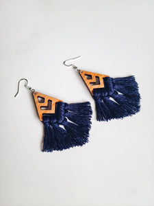 Earrings with a chevron-style wooden design that connects to a navy blue tassel.