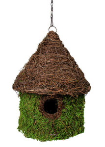 A hanging birdhouse with a tall, brown woven roof and green mossy bottom. The center has a small hole for birds to enter through. 