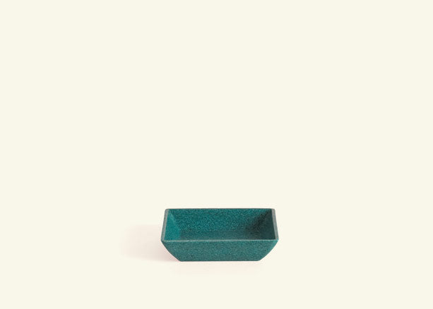 A small rectangular teal saucer.